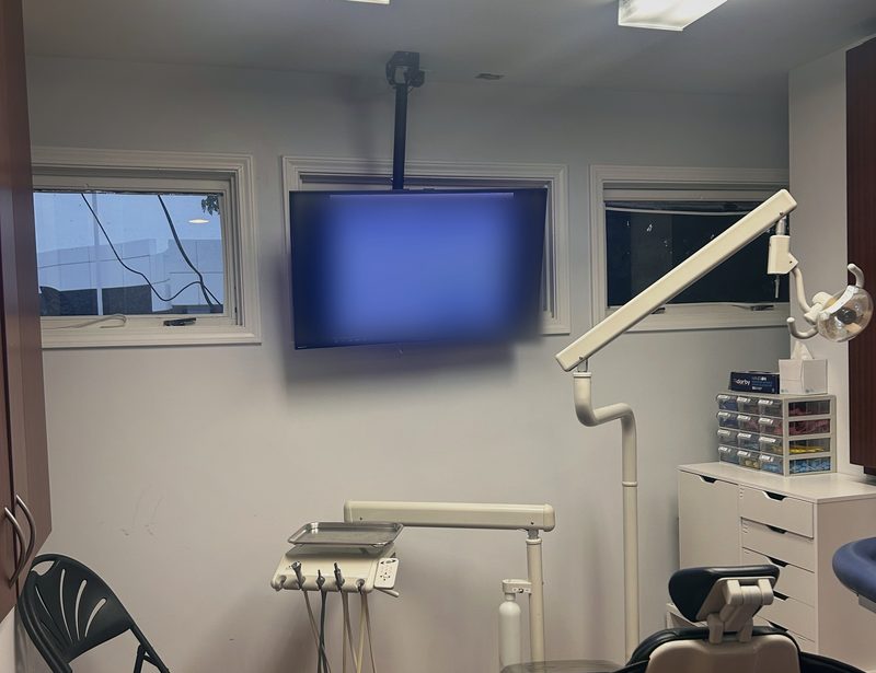 Treatment room with a ceiling-mounted TV